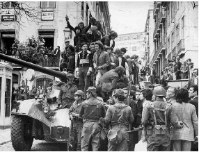 Sort-hvidt foto af en kampvogn med mennesker i en gade i Lissabon i april 1974